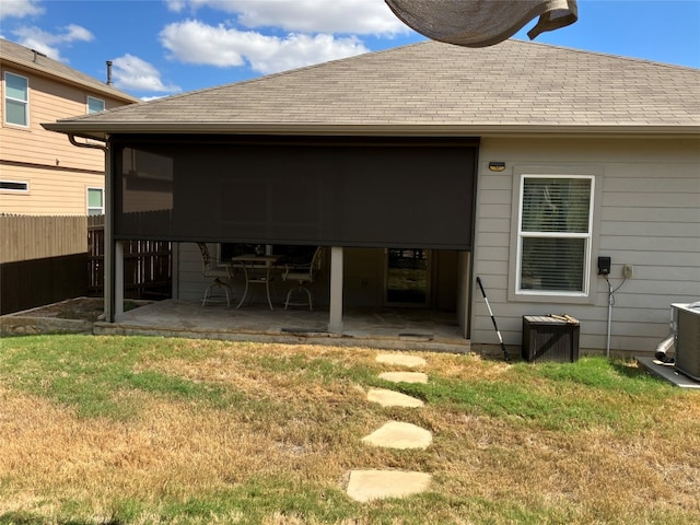 rear view of property with a yard, a patio area, and central AC unit