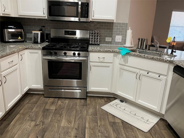 13708 Cantarra Dr, Pflugerville, TX 78660 - kitchen with appliances with stainless steel finishes, a sink, white cabinetry, and dark wood-style floors