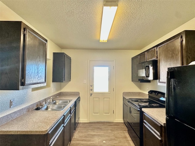 kitchen featuring black appliances, sink, a textured ceiling, dark brown cabinetry, and light hardwood / wood-style flooring