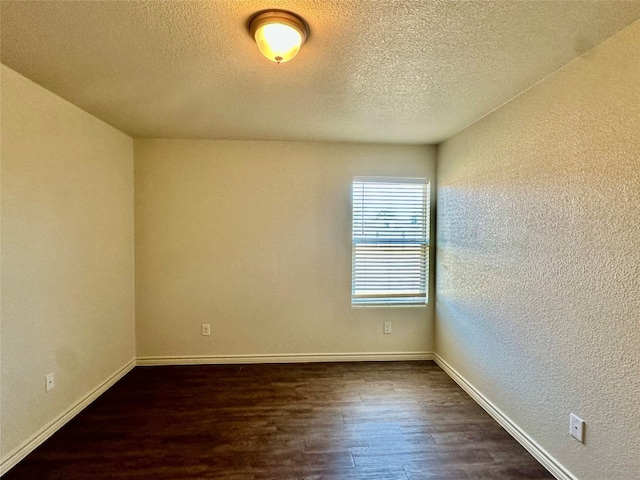 unfurnished room with a textured ceiling and dark hardwood / wood-style flooring