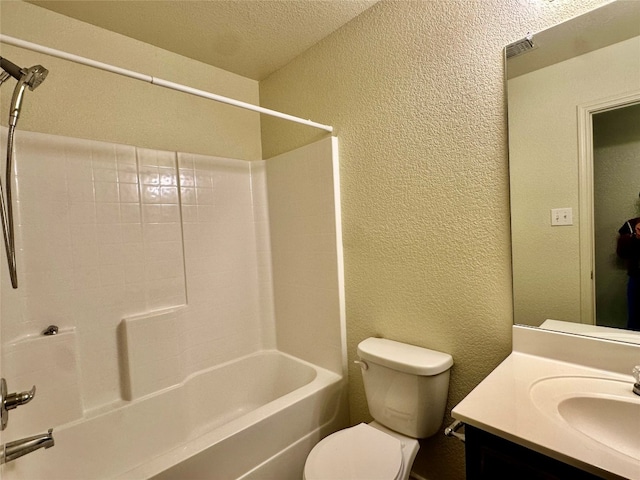 full bathroom featuring vanity, washtub / shower combination, a textured ceiling, and toilet