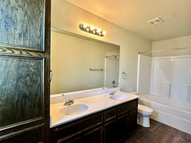 full bathroom featuring toilet, a textured ceiling, vanity, and shower / bath combination