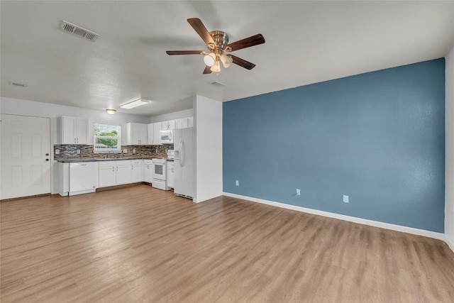 unfurnished living room featuring sink, light hardwood / wood-style floors, and ceiling fan