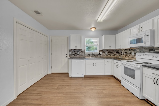 kitchen with light hardwood / wood-style flooring, white cabinetry, sink, and white appliances