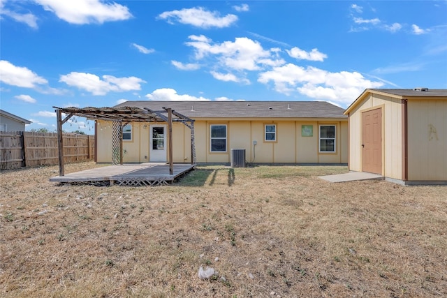 back of property with a storage unit, cooling unit, a patio, a pergola, and a lawn