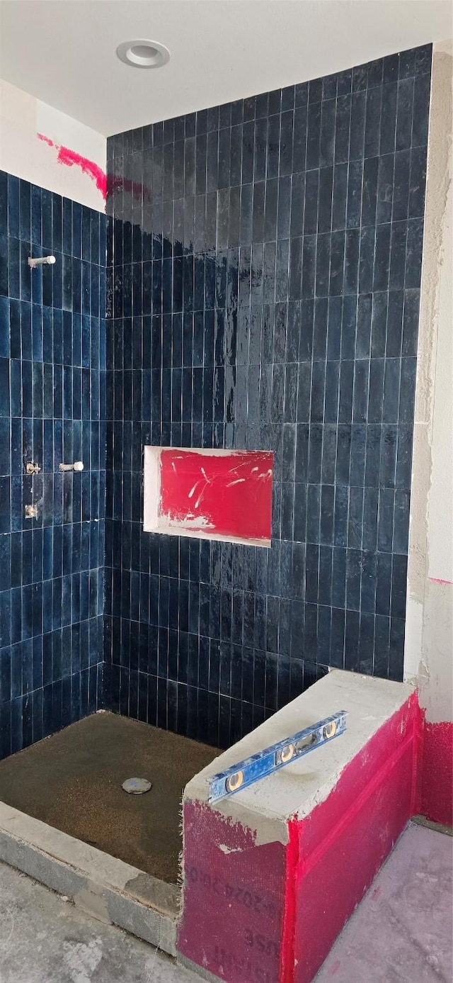 bathroom featuring a shower and tile walls