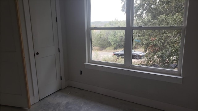 unfurnished bedroom featuring concrete floors and multiple windows