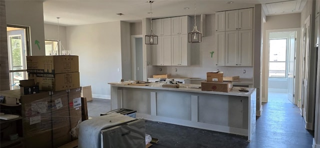 kitchen with concrete flooring, white cabinetry, baseboards, hanging light fixtures, and light countertops