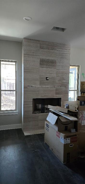 unfurnished living room featuring a healthy amount of sunlight and baseboards