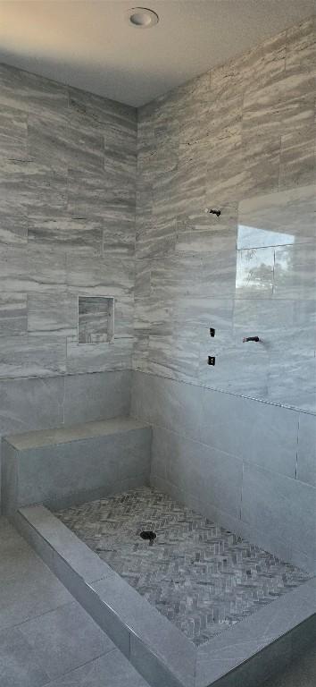 full bathroom with tile patterned flooring and tiled shower