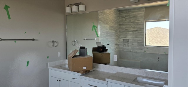 bathroom featuring tiled shower and vanity