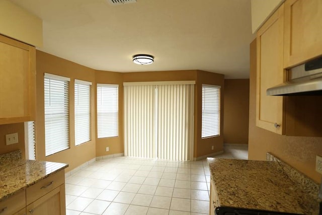 unfurnished dining area featuring light tile patterned floors