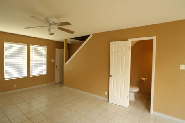 tiled spare room with ceiling fan