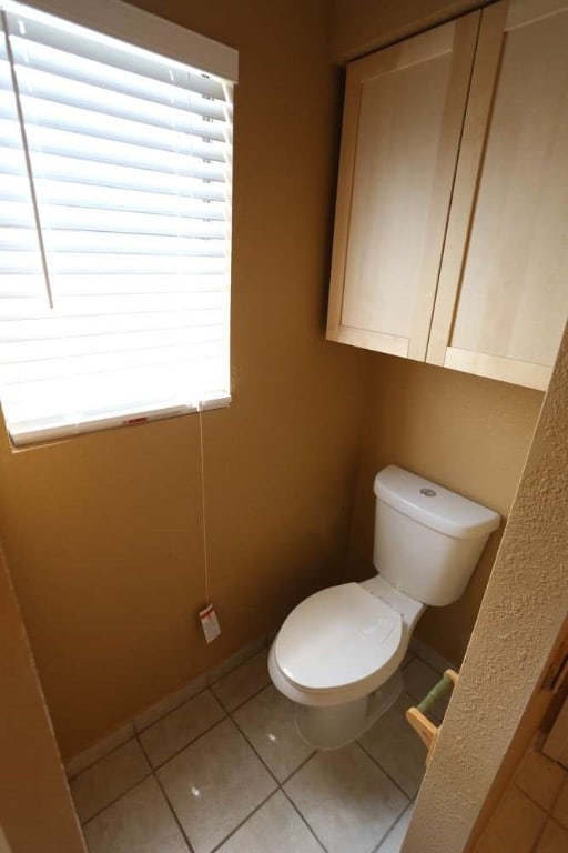 bathroom featuring toilet and tile patterned flooring