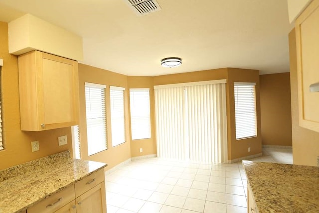 kitchen featuring light stone counters, light brown cabinetry, and light tile patterned floors