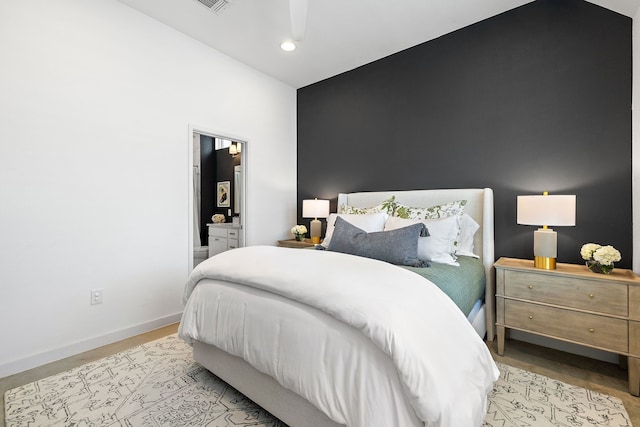 bedroom featuring light wood-type flooring and vaulted ceiling