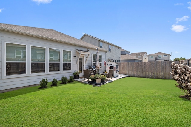 rear view of house featuring a yard and a patio