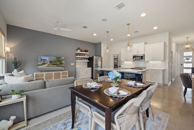 dining space with finished concrete flooring, baseboards, visible vents, and recessed lighting