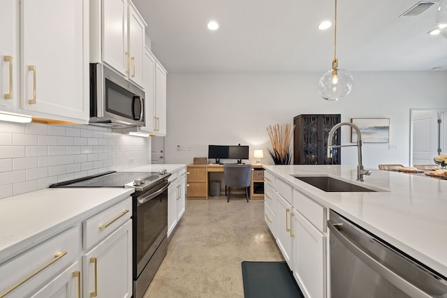 kitchen featuring tasteful backsplash, sink, white cabinets, pendant lighting, and stainless steel appliances