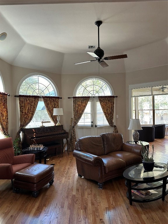 living room featuring hardwood / wood-style flooring, a healthy amount of sunlight, vaulted ceiling, and ceiling fan