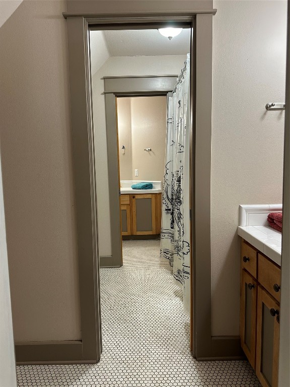 bathroom featuring vanity and lofted ceiling