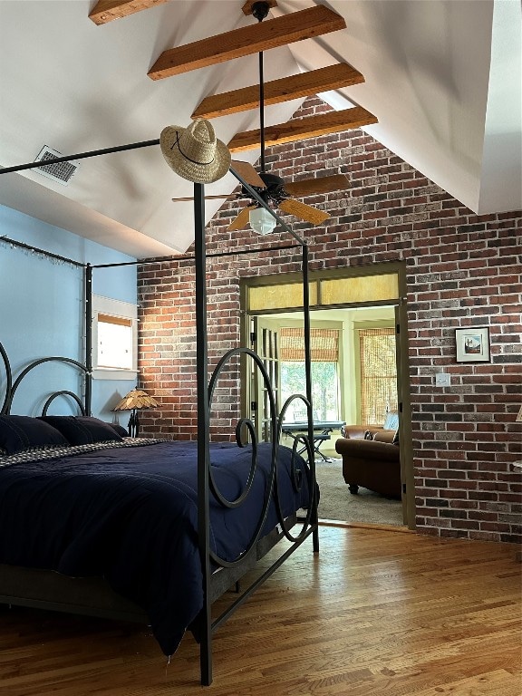 bedroom with hardwood / wood-style floors, brick wall, and ceiling fan