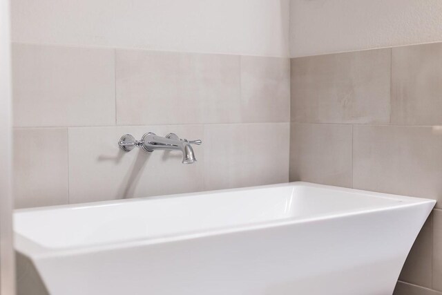 309 Greenway Dr, Georgetown, TX 78628 - bathroom featuring a tub and tile walls
