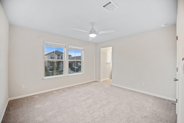 spare room with light colored carpet and ceiling fan