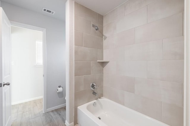 309 Greenway Dr, Georgetown, TX 78628 - full bathroom with baseboards, wood finished floors, visible vents, and shower / bathing tub combination