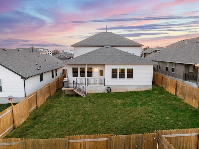 back house at dusk with a lawn