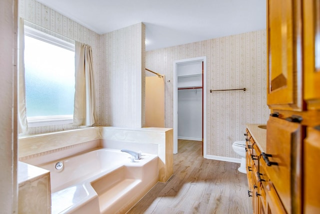 bathroom with vanity, toilet, hardwood / wood-style flooring, and a bath