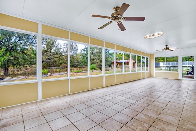 unfurnished sunroom with ceiling fan