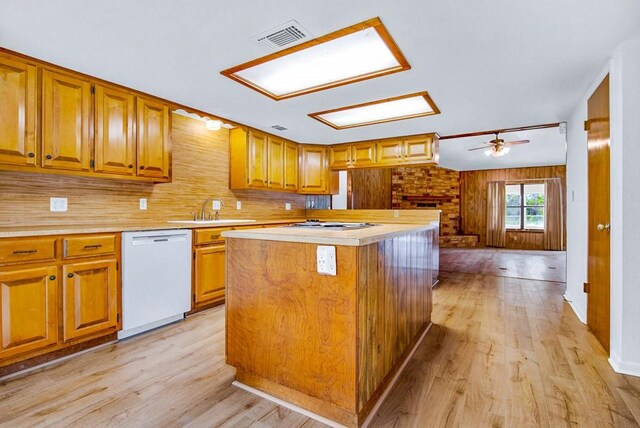 298 Jenkins Rd, Cedar Creek, TX 78612 - kitchen with white dishwasher, a sink, light countertops, and brown cabinetry