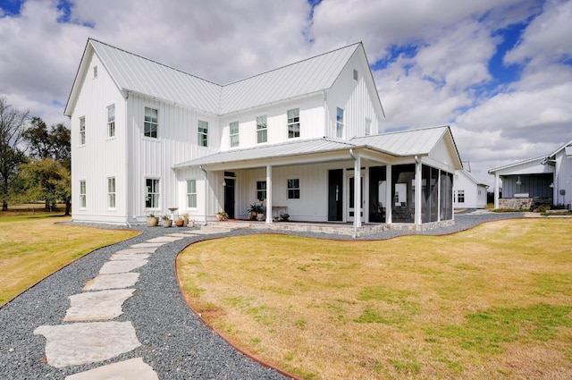 modern farmhouse featuring a front yard and a sunroom