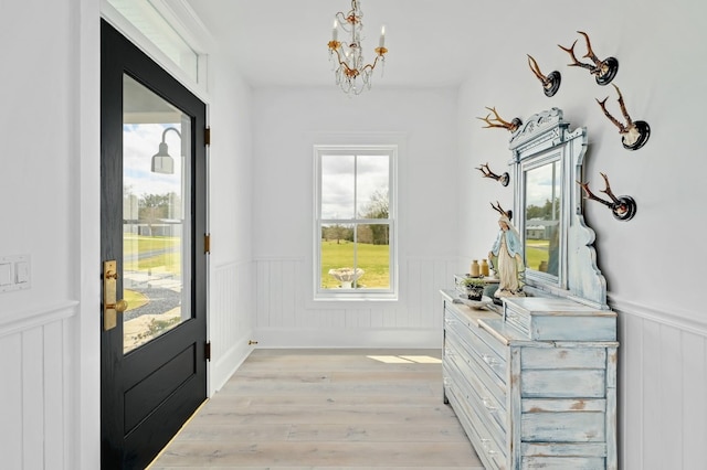 233 W Mill St, Round Top, TX 78954 - doorway with wainscoting, a chandelier, and light wood finished floors