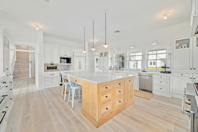 kitchen with dishwasher, a center island, black microwave, and white cabinets