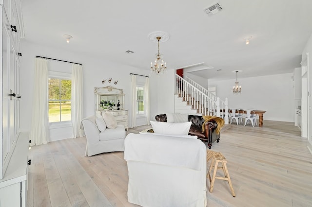 living room with a notable chandelier and light wood-type flooring