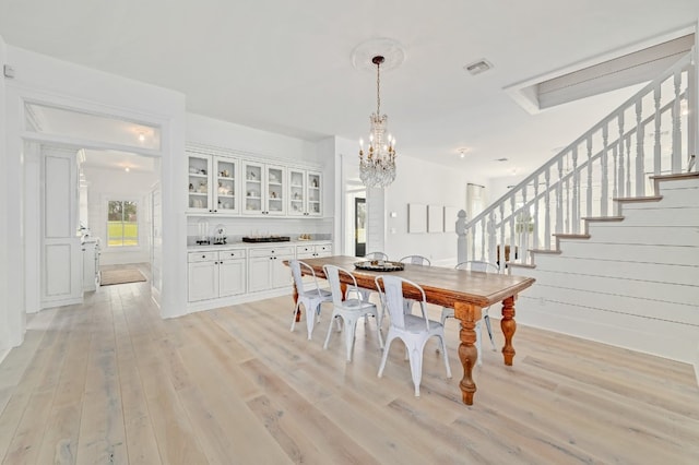 233 W Mill St, Round Top, TX 78954 - dining space featuring light wood finished floors, a chandelier, and stairs