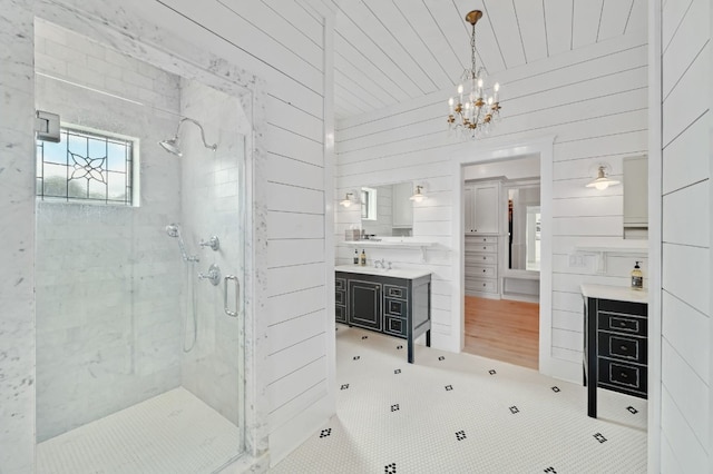 233 W Mill St, Round Top, TX 78954 - bathroom featuring a stall shower, vanity, tile patterned flooring, a chandelier, and wooden walls