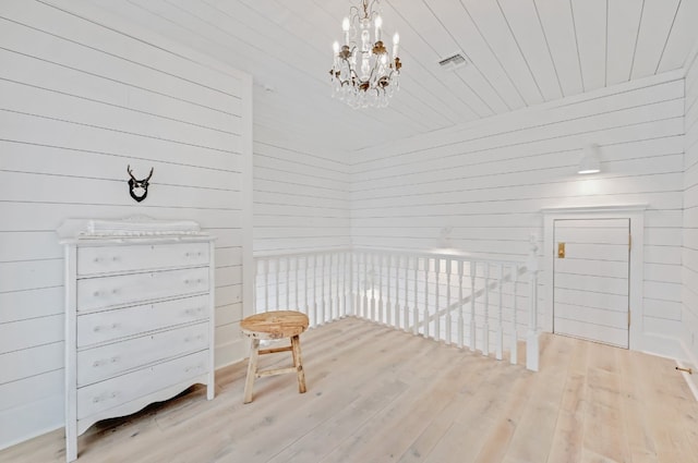 233 W Mill St, Round Top, TX 78954 - sitting room with hardwood / wood-style flooring, a chandelier, wooden walls, an upstairs landing, and wooden ceiling