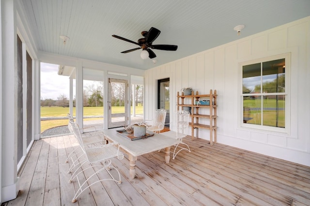 unfurnished sunroom with ceiling fan