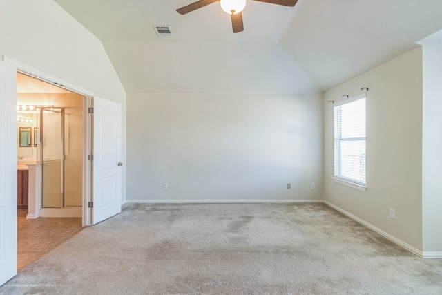 empty room featuring ceiling fan, light colored carpet, and vaulted ceiling