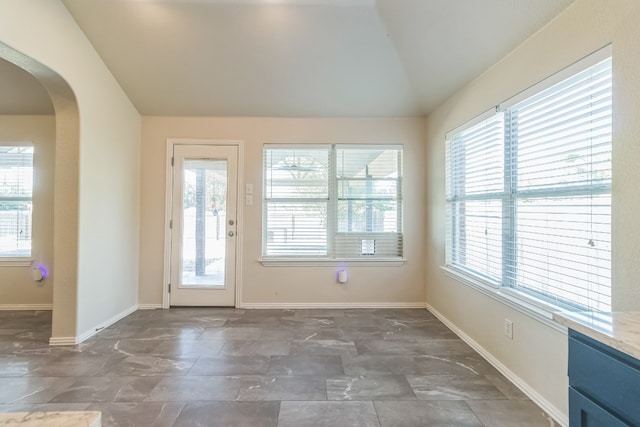 doorway featuring a healthy amount of sunlight and vaulted ceiling