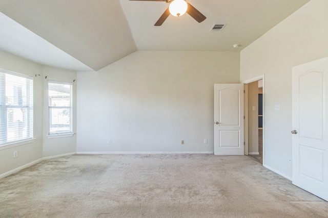 carpeted empty room featuring ceiling fan and lofted ceiling