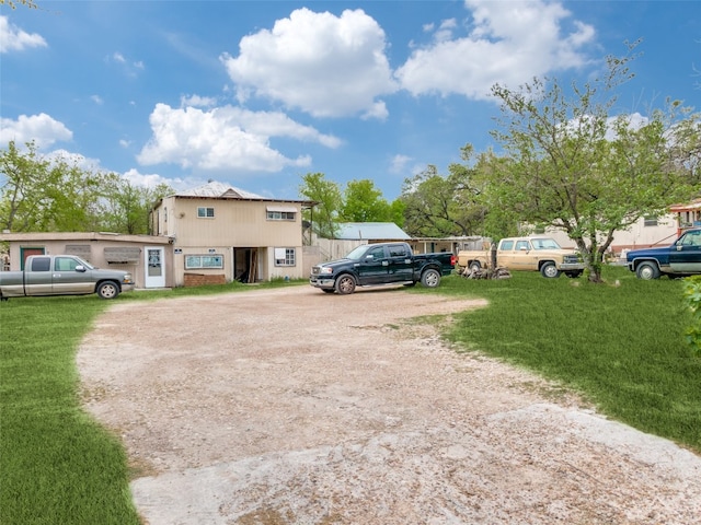 view of parking / parking lot featuring a lawn