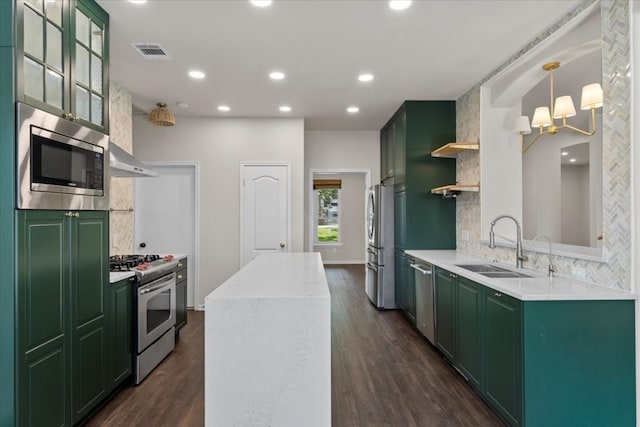 kitchen with decorative backsplash, dark hardwood / wood-style flooring, stainless steel appliances, sink, and green cabinetry