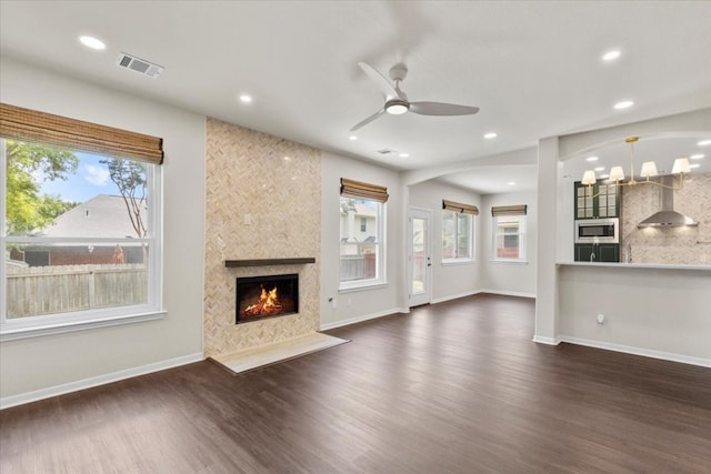 unfurnished living room with dark wood-type flooring, ceiling fan, and plenty of natural light