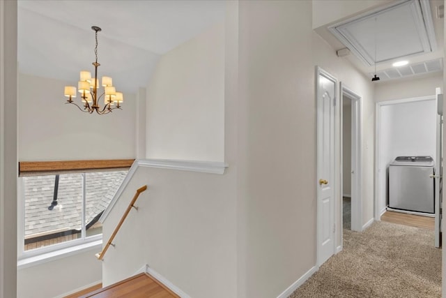 hallway with washer / dryer, light carpet, and vaulted ceiling