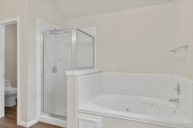 bathroom with toilet, hardwood / wood-style flooring, lofted ceiling, and shower with separate bathtub