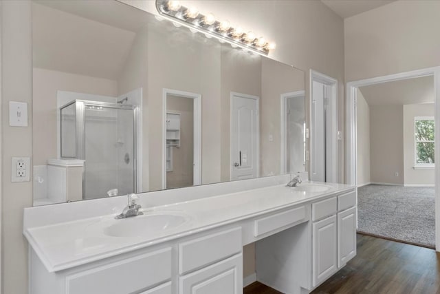 bathroom with vanity, vaulted ceiling, hardwood / wood-style flooring, and a shower with shower door